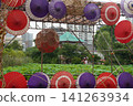 Ueno Park: Lotus flowers in Shinobazu Pond and Bentendo Temple viewed through the colorful Japanese umbrella decorations. 141263934