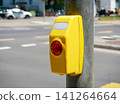 Pedestrian crossing push button on traffic signal pole in urban street. 141264664