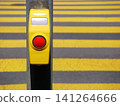 Pedestrian crossing button with yellow striped crosswalk background 141264666