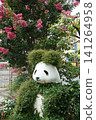 A panda sculpture covered in plants and crape myrtle flowers at the entrance of Ueno Park in summer. 141264958