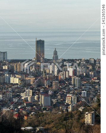 Panoramic view of Batumi city skyline with tall buildings and sea horizon under warm evening light Panoramic view of Batumi city skyline with tall buildings and sea horizon under warm evening light 141265546