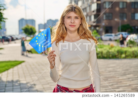 Smiling young woman holding flag of European Union Smiling young woman holding flag of European Union 141265589