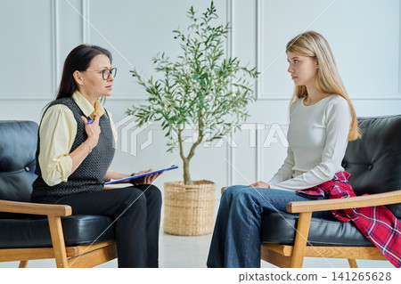 Professional female psychologist explaining solution to teenage girl at therapy 141265628