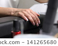 A woman's hand during a manicure. A woman getting a manicure. A manicurist is doing a client's nails at a nail salon. Manicure services. Nail art. Beauty salon. A woman's hand during a manicure. A woman getting a manicure. A manicurist is doing a client's nails at a nail salon. Manicure services. Nail art. Beauty salon. 141265680