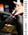 A woman's hand during a manicure. A woman getting a manicure. A manicurist is doing a client's nails at a nail salon. Manicure services. Nail art. Beauty salon. A woman's hand during a manicure. A woman getting a manicure. A manicurist is doing a client's nails at a nail salon. Manicure services. Nail art. Beauty salon. 141265681