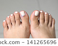 A woman's feet during a pedicure. Woman getting pedicure in beauty salon, closeup. Manicure services. Nail art. Pedicure, nail care, light-colored gel polish with rhinestones. Beauty salon concept: A woman's feet during a pedicure. Woman getting pedicure in beauty salon, closeup. Manicure services. Nail art. Pedicure, nail care, light-colored gel polish with rhinestones. Beauty salon concept: 141265696