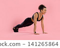 Cheerful young Black woman in sportswear holding high plank position 141265864