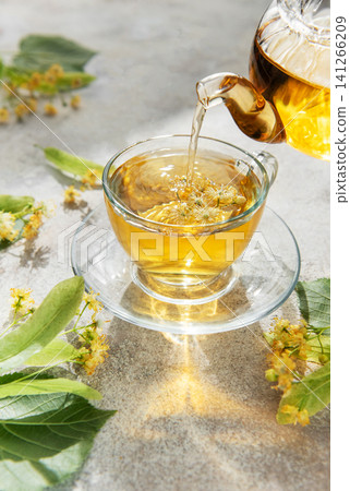 Pouring linden tea into glass cup for relaxation Pouring linden tea into glass cup for relaxation 141266209