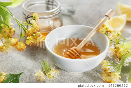 Honey in bowl with dipper and linden flowers Honey in bowl with dipper and linden flowers 141266212