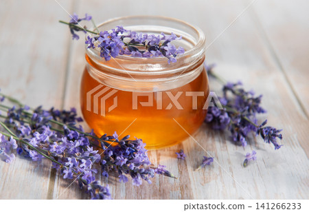 Lavender honey jar with fresh flowers on wood Lavender honey jar with fresh flowers on wood 141266233