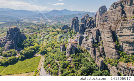 Horizontal aerial view of the ancient Holy Trinity monastery built on a steep giant cliff in Meteora heritage site on a sunny day near Trikala, Thessaly, Greece Horizontal aerial view of the ancient Holy Trinity monastery built on a steep giant cliff in Meteora heritage site on a sunny day near Trikala, Thessaly, Greece 141266617