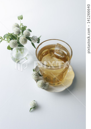 White globe amaranth and iced tea. A refreshing vertical composition for summer. Table photo. Copy space. White globe amaranth and iced tea. A refreshing vertical composition for summer. Table photo. Copy space. 141266640