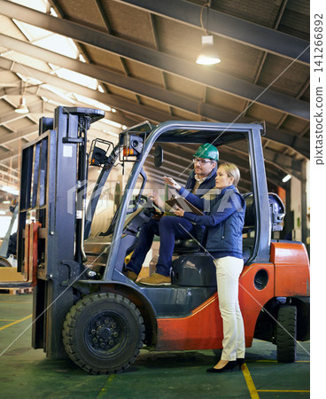 Talking, warehouse and workers with forklift working on site, loading on dock with Industrial moving vehicle. Teamwork, together or woman with clipboard for shipping inventory, hardhat for safety Talking, warehouse and workers with forklift working on site, loading on dock with Industrial moving vehicle. Teamwork, together or woman with clipboard for shipping inventory, hardhat for safety 141266892