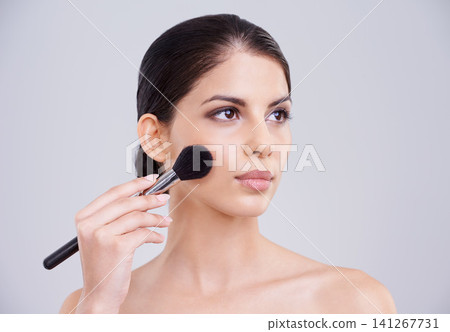 Woman, makeup and application brush in studio for beauty blush, cosmetics or grey background. Female person, facial contour and treatment transformation for makeover wellness, mockup space or routine 141267731