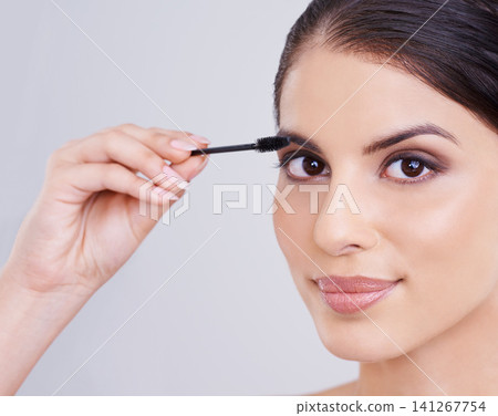 Hand, mascara and brush with woman in portrait, beauty for lashes and cosmetology on white background. Makeup, glow and transformation for makeover, cosmetic product and wand for eyelash with volume Hand, mascara and brush with woman in portrait, beauty for lashes and cosmetology on white background. Makeup, glow and transformation for makeover, cosmetic product and wand for eyelash with volume 141267754