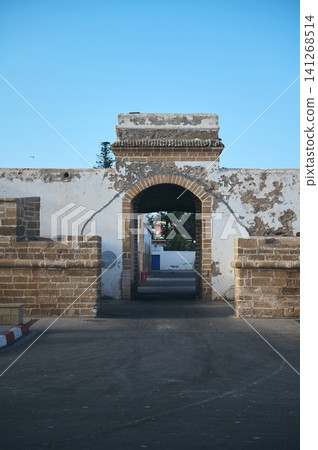 Historic arched gate in Essaouira, Morocco with weathered walls and coastal authenticity Historic arched gate in Essaouira, Morocco with weathered walls and coastal authenticity 141268514