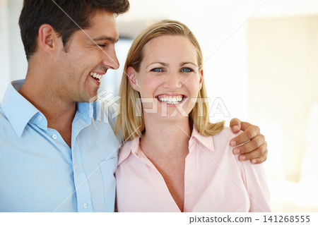 Couple, hug and smile together in portrait for love, romance or memories in home. Laughing, man and woman embrace in house happy, bonding and sentimental for relationship, affection or support 141268555