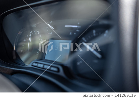 Close-up view of a speedometer displaying a speed of 37 while driving on a clear day, showcasing the dashboard of a compact vehicle. Close-up view of a speedometer displaying a speed of 37 while driving on a clear day, showcasing the dashboard of a compact vehicle. 141269139