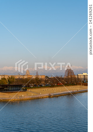 Fugan Canal Kansui Park at dusk, with the snow-capped Tateyama mountain range towering in the distance (Toyama Prefecture) Fugan Canal Kansui Park at dusk, with the snow-capped Tateyama mountain range towering in the distance (Toyama Prefecture) 141269261