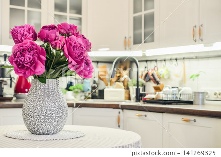 Pink peony bouquet in a kitchen interior Pink peony bouquet in a kitchen interior 141269325