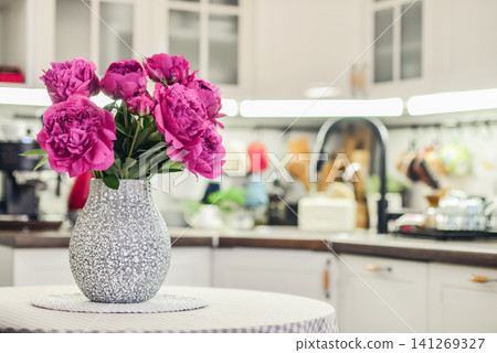Pink peony bouquet in a kitchen interior Pink peony bouquet in a kitchen interior 141269327