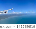 The white wings of the aircraft stand out against the blue sky, and the magnificent coastline stretches out below. 141269619
