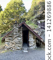 A historic stone cottage with a triangular roof stands in Arrowtown, New Zealand. 141269886