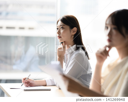 A woman taking notes in a meeting A woman taking notes in a meeting 141269948