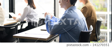 A man holding a pen in a meeting A man holding a pen in a meeting 141270351