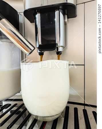 A clear glass filled with thick milk foam before the espresso is added to a latte macchiato. Creamy milk base at home A clear glass filled with thick milk foam before the espresso is added to a latte macchiato. Creamy milk base at home 141270897
