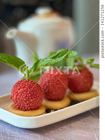 Delicate lychee dessert with mint and biscuit served on a white plate Delicate lychee dessert with mint and biscuit served on a white plate 141271256