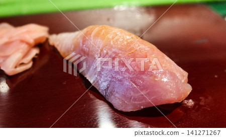 close up of Japanese tuna (toro) nigiri sushi served on a glossy dark plate with sweet pink pickled ginger on the side and copy space close up of Japanese tuna (toro) nigiri sushi served on a glossy dark plate with sweet pink pickled ginger on the side and copy space 141271267