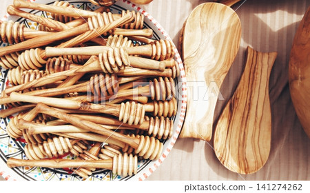 handcrafted olive wood honey dippers and wooden spoons at a craft market display. handcrafted olive wood honey dippers and wooden spoons at a craft market display. 141274262