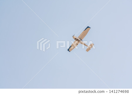 Small ultralight airplane with overhead wing and single propeller flying in sunset sky. Small ultralight airplane with overhead wing and single propeller flying in sunset sky. 141274698