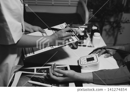 Mid section of doctor checking blood pressure of a patient Mid section of doctor checking blood pressure of a patient 141274854