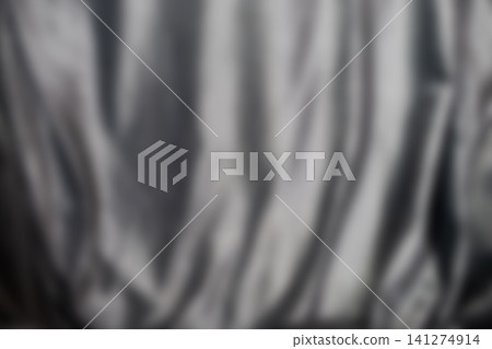 Blurred metallic curtain folds with soft highlights and deep shadows across smooth satin surface, creating elegant silver texture, gentle sheen, and moody abstract backdrop for luxury design Blurred metallic curtain folds with soft highlights and deep shadows across smooth satin surface, creating elegant silver texture, gentle sheen, and moody abstract backdrop for luxury design 141274914