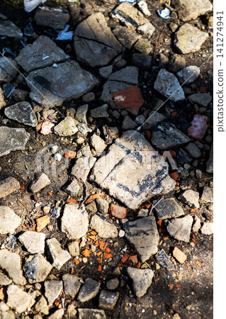 Sunlit rocky ground with scattered gravel and soil Sunlit rocky ground with scattered gravel and soil 141274941