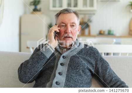 Happy middle aged senior man talking on smartphone with family friends. Older mature grandfather with cell phone talking with grown up children, resting at home. Older generation modern tech usage Happy middle aged senior man talking on smartphone with family friends. Older mature grandfather with cell phone talking with grown up children, resting at home. Older generation modern tech usage 141275670