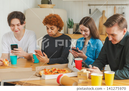 Home party. Friends holding smartphones touch screen typing scroll page in kitchen at home. People with cell phones surfing internet using social media apps on party, Internet news cellphone addiction Home party. Friends holding smartphones touch screen typing scroll page in kitchen at home. People with cell phones surfing internet using social media apps on party, Internet news cellphone addiction 141275970