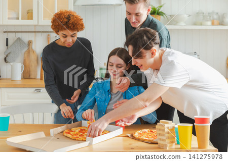 Home party. Overjoyed diverse friends eating ordered pizza for home party. Happy group multiracial young buddies enjoying spending free weekend time together having fun laughing joking communicating Home party. Overjoyed diverse friends eating ordered pizza for home party. Happy group multiracial young buddies enjoying spending free weekend time together having fun laughing joking communicating 141275978