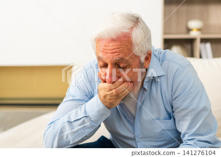 Healthcare medicine. Senior man with high fever symptoms illness cold seasonal influenza covering mouth with his hand coughing. Elderly man with seasonal infections flu suffering from disease pain Healthcare medicine. Senior man with high fever symptoms illness cold seasonal influenza covering mouth with his hand coughing. Elderly man with seasonal infections flu suffering from disease pain 141276104