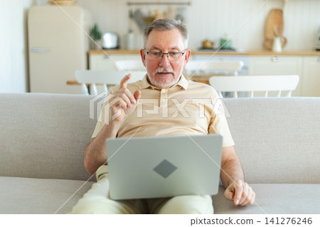 Happy middle aged senior man with laptop talk on video call with friends family. Mature old senior grandfather having fun talking with grown up children online. Older generation modern tech usage Happy middle aged senior man with laptop talk on video call with friends family. Mature old senior grandfather having fun talking with grown up children online. Older generation modern tech usage 141276246