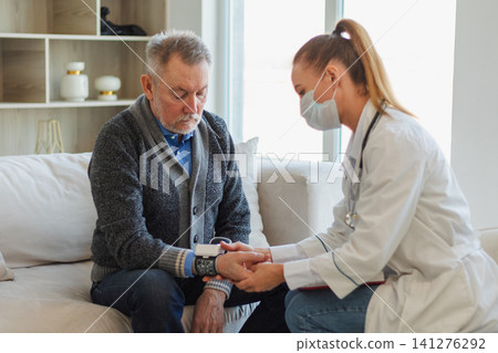 Female doctor senior man taking his blood pressure in doctor office or at home. Old man patient and doctor have consultation in hospital room. Medicine healthcare medical checkup. Visit to doctor Female doctor senior man taking his blood pressure in doctor office or at home. Old man patient and doctor have consultation in hospital room. Medicine healthcare medical checkup. Visit to doctor 141276292