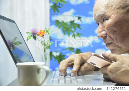 Close-up of a laptop and an old man's face Close-up of a laptop and an old man's face 141276851