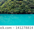 The turquoise blue Kurobe River and the green trees on the opposite bank. 141278814