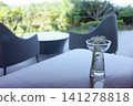White flowers decorating a glass on a terrace table 141278818