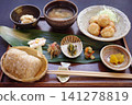 A meal consisting of various side dishes and brown rice onigiri. 141278819
