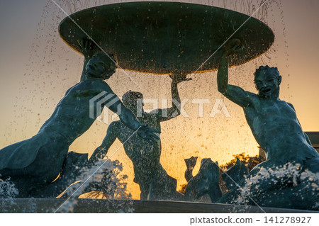 VALLETTA, MALTA - NOVEMBER 12, 2018 - The Triton Fountain In The City Gate Square with springs of water in the sunset 141278927