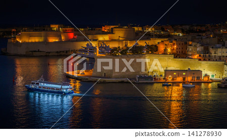 VALLETTA, MALTA - NOVEMBER 12, 2018 - Panoramic night view of a coast line and the downtown of the city with different landmarks 141278930