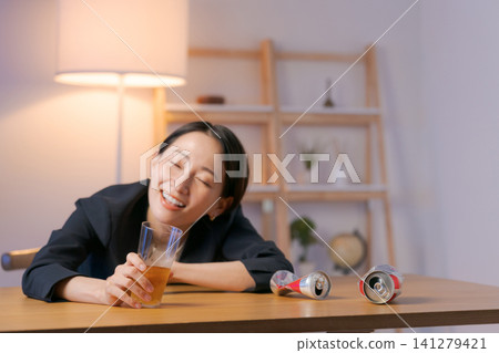 一個穿著西裝的女人喝啤酒喝醉了。 一個穿著西裝的女人喝啤酒喝醉了。 141279421